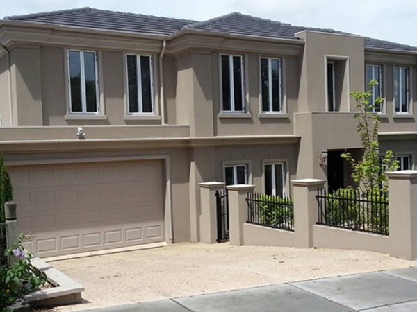 A close-up shot of a scraped-texture external render in a contemporary charcoal grey, revealing the subtle horizontal lines and depth of the finish
